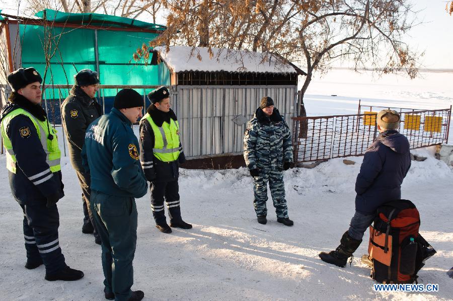 Russian police and members of Russian ministry of emergency situations block the way to site of the meteorite fall at the chebarkul lake near Chelyabinsk, about 1500 kilometers east of Moscow, Russia, Feb. 16, 2013. A meteorite burst into the sky over Russia's Urals region on Friday. Emergency Situations Minister Vladimir Puchkov said there was no proof that meteoritic fragments have been found. (Xinhua/Jiang Kehong) 