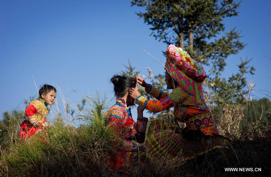 Zhang Lu (C), a bride of the Lisu ethnic group, has her face shaven before her wedding in Xinyu Village of Dechang County, southwest China's Sichuan Province, Feb. 15, 2013. Dechang's Lisu people live in family- or clan-based villages most of which locates on river valley slopes of around 1,500 to 3,000 meters above the sea level. They still practice a wedding tradition that has uncommon conventions including bridal face-shaving, outdoor wedding banquet and overnight group dance. (Xinhua/Jiang Hongjing) 