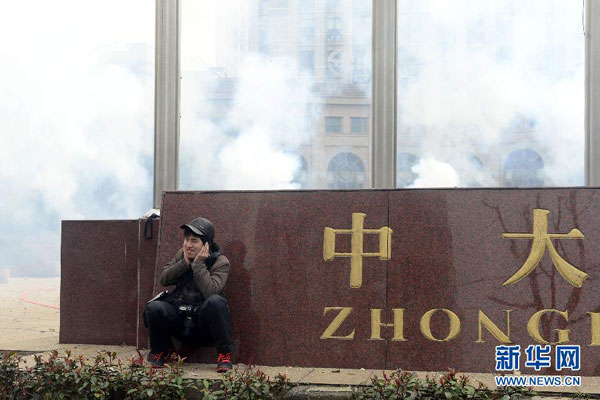 A photographer covers his ears with hands to avoid firework noise at a plaza in Hangzhou, eastern China's Zhejiang province, Saturday morning, February 16, 2013. Firework sprees are staged in many places around China on Saturday morning, the first workday after this year's Spring Festival holidays. Many Chinese businessmen pray this way for a properous new year, but such activities have also been blamed for burdening cleaning workers and worsening air pullution. (Photo/Xinhua) 