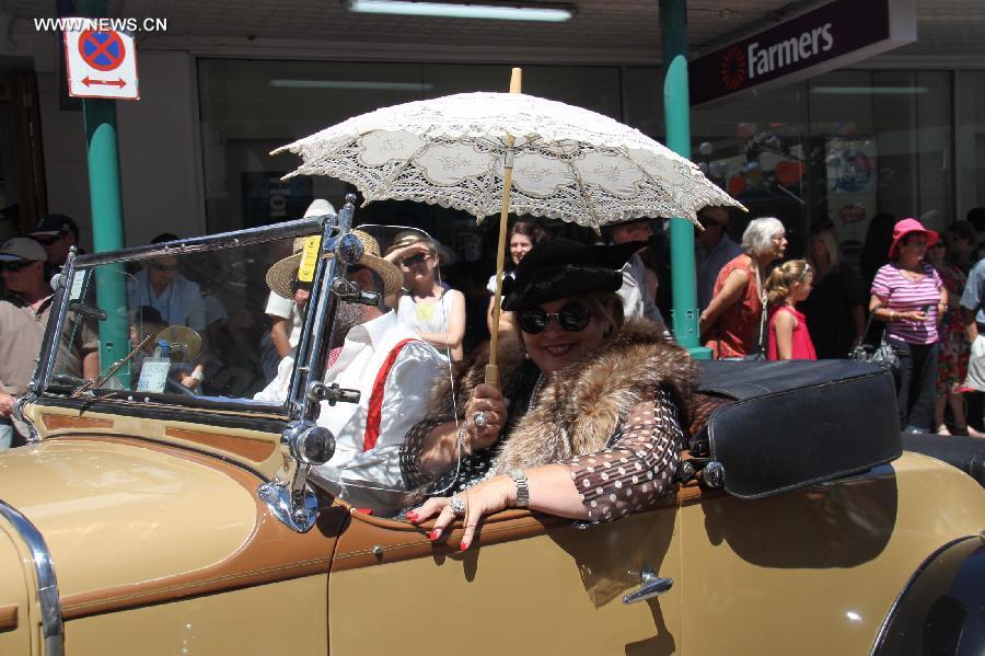 People drive a vintage car in the Vintage Car Parade in Napier, New Zealand, Feb. 16, 2013. More than 300 vintage cars joined the parade, the highlight of the annual Art Decor Weekend festival. (Xinhua/Liu Jieqiu)