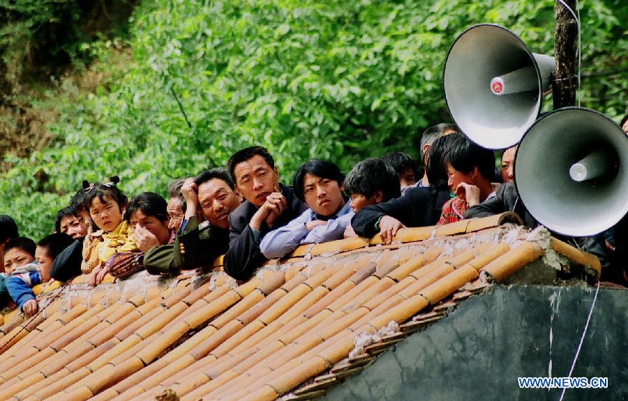 File photo taken on April 27, 2002 shows villagers gathering on a rooftop to watch a Shehuo performance in Wangwu Township of Jiyuan, central China's Henan Province. (Xinhua/Wang Song)