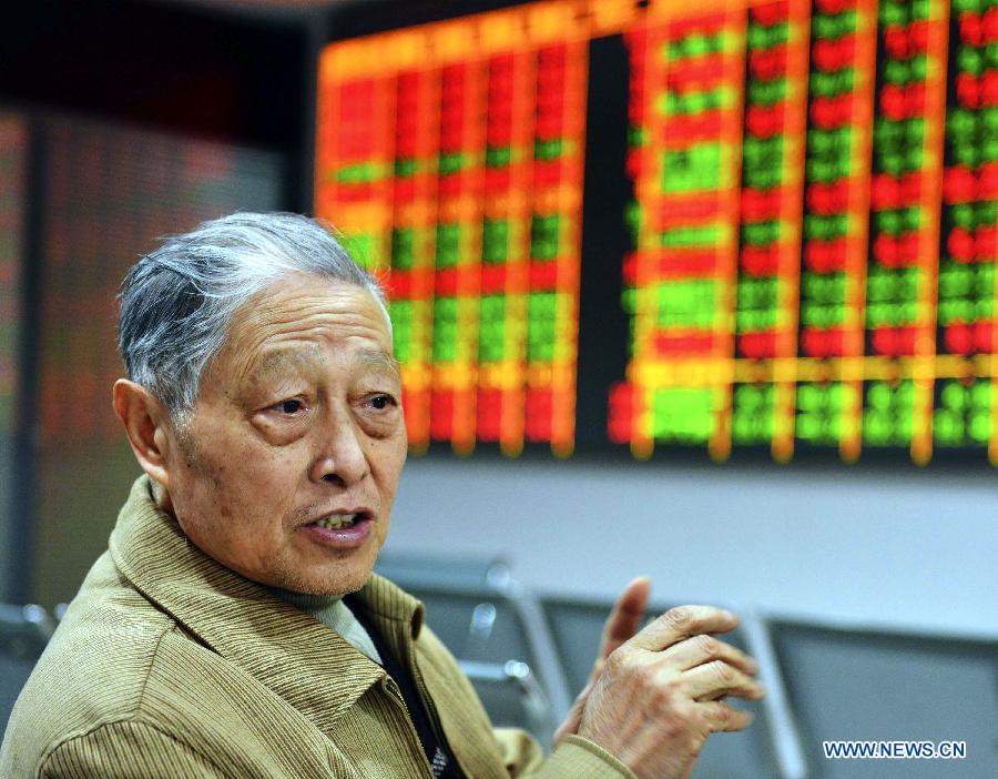 An investor talks with other people at a securities trading center in Hangzhou, capital of east China's Zhejiang Province, Feb. 18, 2013. Chinese stocks closed lower on Monday. The benchmark Shanghai Composite Index closed at 2,421.56 points, down 0.45 percent, or 10.84 points. The Shenzhen Component Index dropped 1.93 percent, or 193.19 points, to end at 9,795.91. (Xinhua)