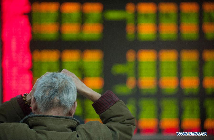 An investor views share price information at a securities trading center in Beijing, capital of China, Feb. 18, 2013. Chinese stocks closed lower on Monday. The benchmark Shanghai Composite Index closed at 2,421.56 points, down 0.45 percent, or 10.84 points. The Shenzhen Component Index dropped 1.93 percent, or 193.19 points, to end at 9,795.91. (Xinhua/Zhang Yu)
