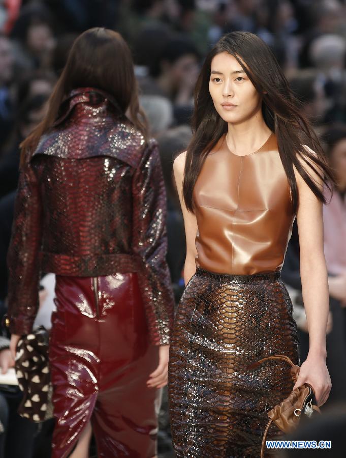 Chinese model Liu Wen (R) presents a creation during the Burberry Prorsum Autumn/Winter 2013 Womenswear Show at Kensington Gardens during London Fashion Week in London, Britain, on Feb. 18, 2013.(Xinhua/Wang Lili) 