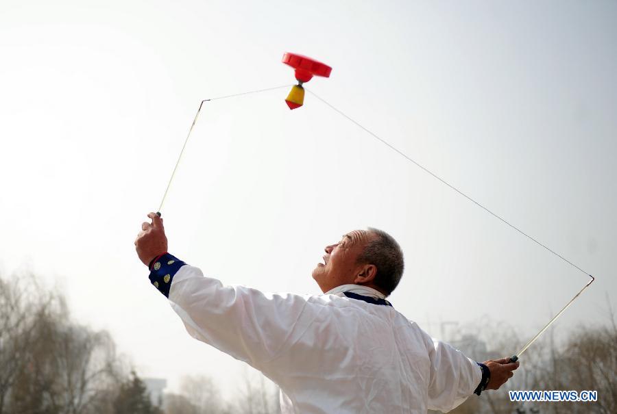 A man plays diabolo at a park in Lanzhou, capital of northwest China's Gansu Province, Feb. 19, 2013. Over a hundred diabolo players gathered here on Tuesday performing their stunts for residents. (Xinhua/Zhang Meng) 