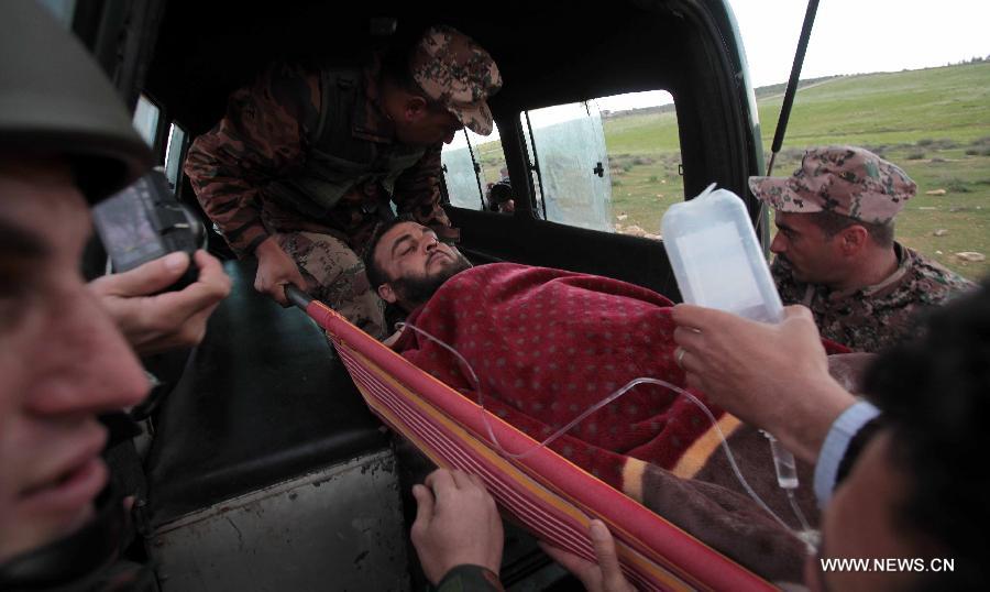 A Syrian refugee, who was injured while crossing the border from Syria into Jordan, is carried onto an ambulance near Mafraq in Jordan, Feb. 18, 2013. According to the Jordanian Armed Forces sources, around 89,000 Syrian refugees fleeing from the violence in their country have crossed the Jordanian border since the beginning of 2013. (Xinhua/Mohammad Abu Ghosh)  