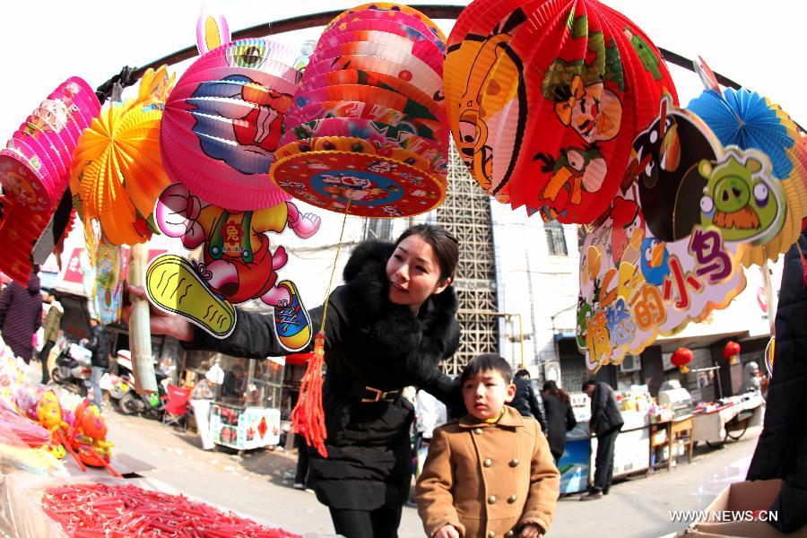 A mother chooses lanterns for her son at a market in Bozhou, east China's Anhui Province, Feb. 20, 2013. An annual lantern sales boom appeared with the approaching of the Lantern Festival which falls on Feb. 24 this year. (Xinhua/Liu Qinli) 