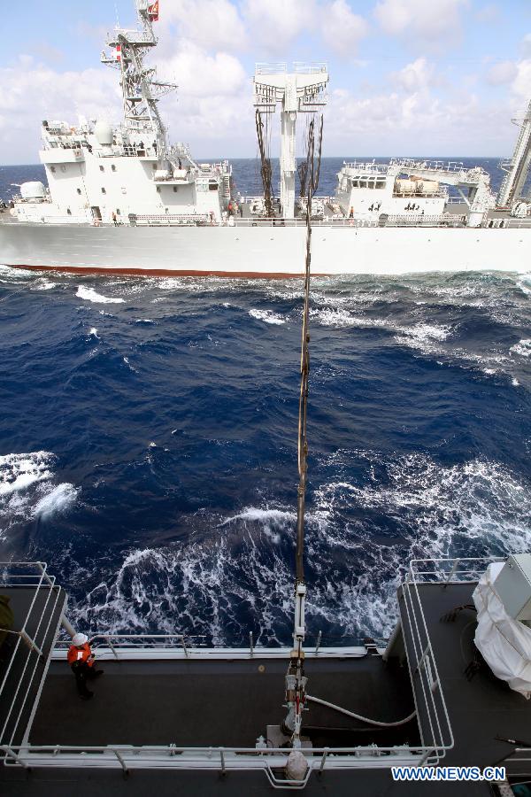 Supply ship Weishanhu (Top) tranport fuel and other materials to Missle destroyer Harbin at the South China Sea, Feb. 20, 2013. The supply ship Weishanhu reinforced the missile destroyer Harbin and the frigate Mianyang on Wednesday with fuel, fresh water and other materials. The 14th naval squad, sent by the Chinese People's Liberation Army (PLA) Navy, departed Saturday from China to the Gulf of Aden and Somali waters for escort missions. The fleet comprises three ships -- the missile destroyer Harbin, the frigate Mianyang and the supply ship Weishanhu -- carrying two helicopters and a 730-strong troop. (Xinhua/Rao Rao)