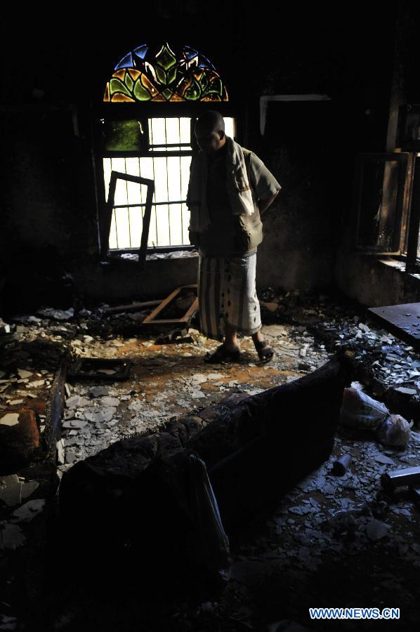 A man inspects his house that was damaged by a crashed plane, in Sanaa, Yemen, on Feb. 20, 2013. The Yemeni supreme security commission said the death toll from Tuesday's fighter jet crash has hit 10, including two children, in a residential area of the capital Sanaa, according to a statement carried by state-run Saba news agency. (Xinhua/Mohammed Mohammed) 