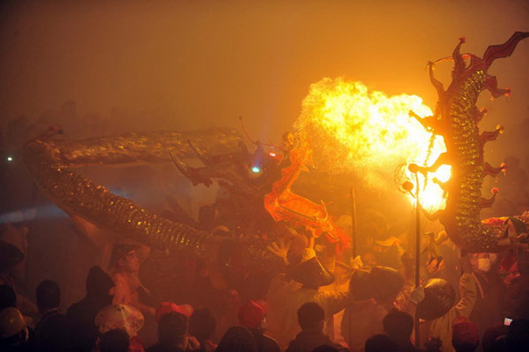 People perform a dragon dance among the fireworks in downtown Bingyang county in South China's Guangxi Zhuang autonomous region on Feb 20, 2013. (Photo/Xinhua) 