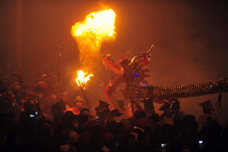 People perform a dragon dance among the fireworks in downtown Bingyang county in South China's Guangxi Zhuang autonomous region on Feb 20, 2013. (Photo/Xinhua) 