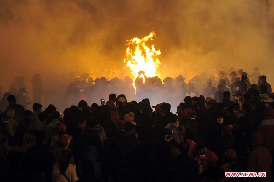 People perform dragon dance in firecrackers in Binyang County of south China's Guangxi Zhuang Autonomous Region, Feb. 20, 2013. The Binyang-style dragon dance is a derivative of traditional dragon dance in which performers hold dragon on poles and walk through floods of firecrackers. The dance, dating back to over 1,000 years ago, was listed as a state intangible cultural heritage in 2008. (Xinhua/Huang Xiaobang) 