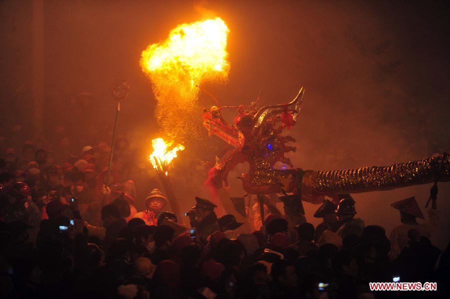 People perform dragon dance in firecrackers in Binyang County of south China's Guangxi Zhuang Autonomous Region, Feb. 20, 2013. The Binyang-style dragon dance is a derivative of traditional dragon dance in which performers hold dragon on poles and walk through floods of firecrackers. The dance, dating back to over 1,000 years ago, was listed as a state intangible cultural heritage in 2008. (Xinhua/Huang Xiaobang) 