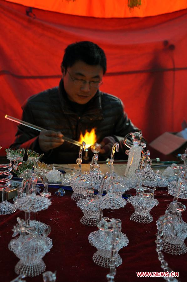 An artist works on a craftwork at a temple fair in Taiyuan, capital of north China's Shanxi Province, Feb. 20, 2013. During the time between the Spring Festival and the Lantern Festival, many activities of intangible cultural heritages at the temple fair in Taiyuan attracted many visitors.(Xinhua/Wang Feihang) 