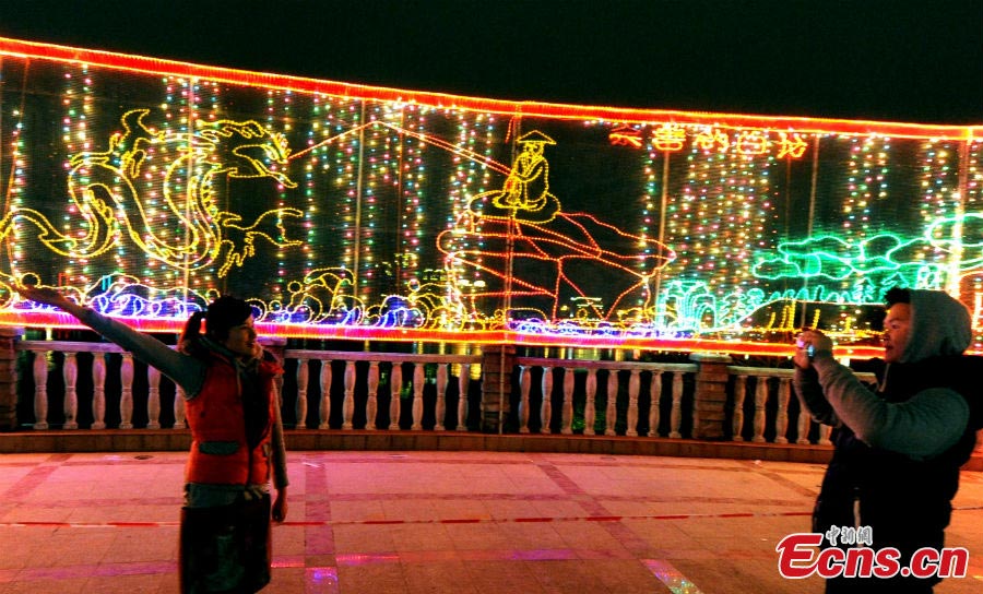 A girl takes photos in front of lanterns of various shapes at Minjiang Park in Fuzhou, Fujian Province, February 20, 2013. (CNS/Liu Kegeng)