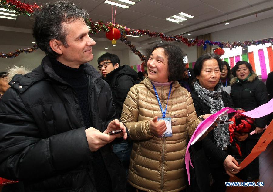 Dawei (1st L) from Spain takes part in a puzzle game at a community in Shanghai, east China, Feb. 21, 2013. Some foreign students on Thursday came to a community in Shanghai to feel the atmosphere of the upcoming Lantern Festival. (Xinhua/Chen Fei) 