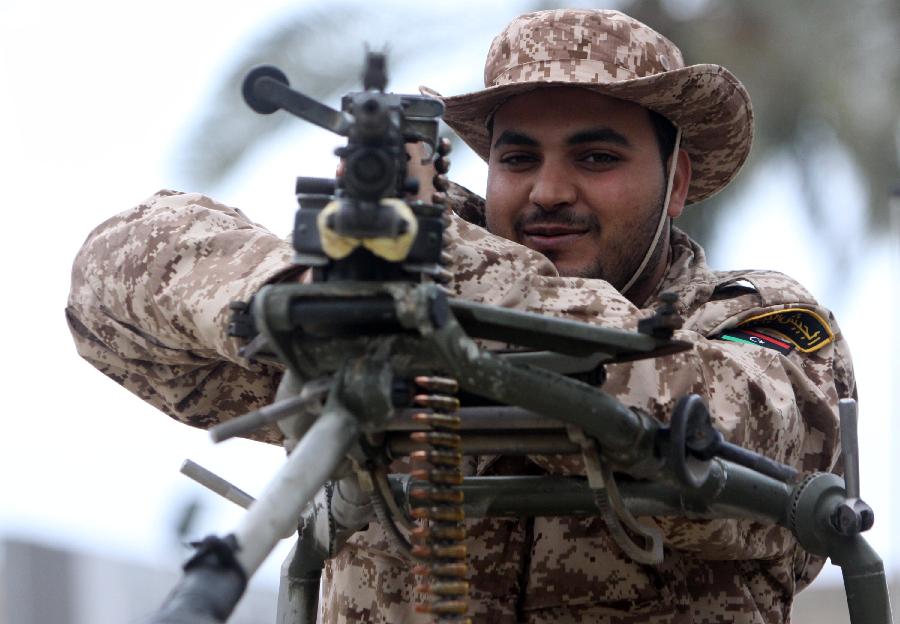 A Libyan soldier demonstrates his skills during a military parade for the second anniversary of a political upheaval that toppled former leader Muammar Gaddafi in the Libyan capital Tripoli, on Feb. 21, 2013 (Xinhua/Hamza Turkia) 