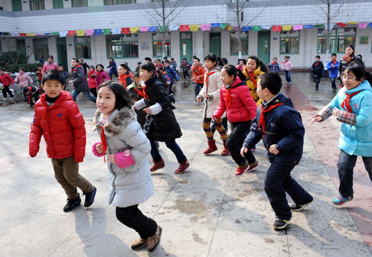 Students run back to classrooms to attend classes in a primary school in Nanjing, Jiangsu province on Thursday, the first day of the new semester for around 800,000 students in the city's kindergartens, primary and secondary schools. The starting day, scheduled for Tuesday, was postponed due to a sudden snowfall that blanketed the province late on Monday night. (Photo/Xinhua) 