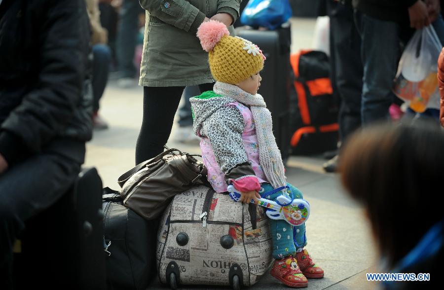 A child waits at the railway station in Chengdu, capital of southwest China's Sichuan Province, Feb. 22, 2013. As the number of travellers rises before the Lantern Festival, many children went back with their parents back to the workplaces. (Xinhua/Xue Yubin)