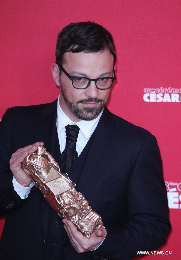 French director Cyril Mennegun holds his Best First Film award for 'Louise Wimmer' as he poses for photos during the 38th annual Cesar awards ceremony held at the Chatelet Theatre in Paris, France, Feb. 22, 2013. (Xinhua/Gao Jing)