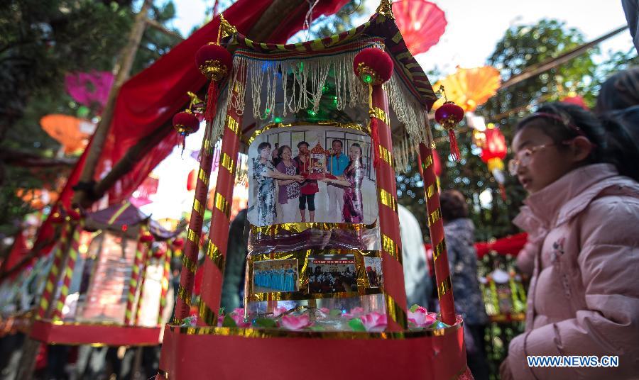 A girl looks at a lantern made from used boxes, bottles and photos at a lantern show in Baibuting community in Wuhan, capital of central China's Hubei Province, Feb. 23, 2013. More than 8,000 lanterns, mostly made from recycled materials by local residents, were displayed at the community in Wuhan on Saturday to celebrate the upcoming traditional Lantern Festival. (Xinhua/Cheng Min)