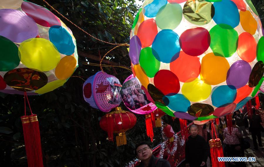 People walk under lanterns made from disposable plastic cups at a lantern show in Baibuting community in Wuhan, capital of central China's Hubei Province, Feb. 23, 2013. More than 8,000 lanterns, mostly made from recycled materials by local residents, were displayed at the community in Wuhan on Saturday to celebrate the upcoming traditional Lantern Festival. (Xinhua/Cheng Min) 