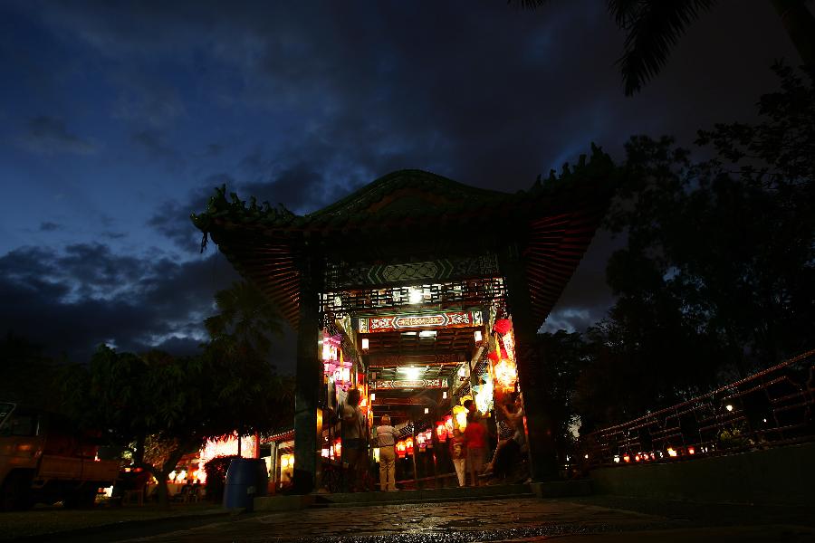 People walk past Chinese lanterns during the 12th China-Philippines Traditional Cultural Festival and Suzhou Cultural Exhibition at the Rizal Park in Manila, the Philippines, Feb. 23, 2013. The 12th China-Philippines Traditional Cultural Festival and Suzhou Cultural Exhibition opened here on Saturday, one day ahead of the Chinese Lantern Festival. (Xinhua/Rouelle Umali)