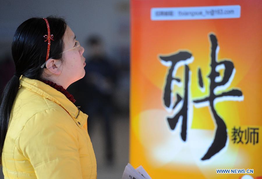  A job seeker reads employment information at a job fair in Beijing, capital of China, Feb. 23, 2013. About 25,000 job opportunities were offered at the job fair. (Xinhua/Luo Xiaoguang) 