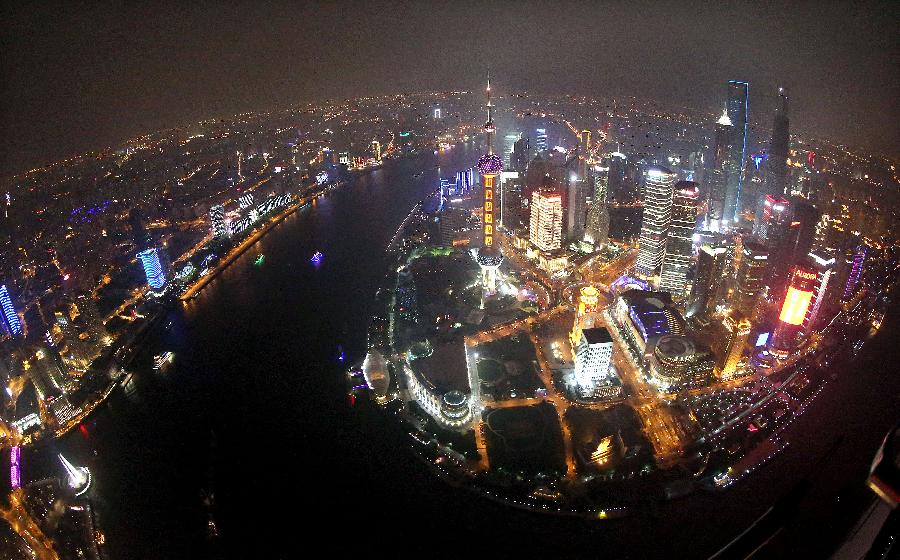 Photo taken on Feb. 24, 2013 shows the aerial view of the illuminated buildings along the banks of the Huangpu River in Shanghai, east China. (Xinhua/Fan Jun)