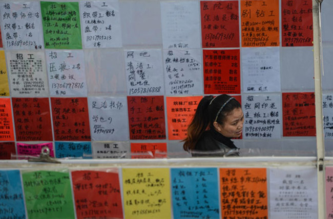 A woman seeks job at a job fair in Yiwu, Zhejiang on Feb 16, 2013. After the weeklong Spring Festival holiday, the resurgence of job market began in China again. (Xinhua/Han Chuanhao)