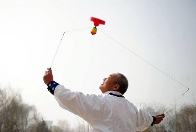 A performer plays diabolo at Lanzhou Stadium Park on Feb 19, 2013. (Photo/Xinhua)