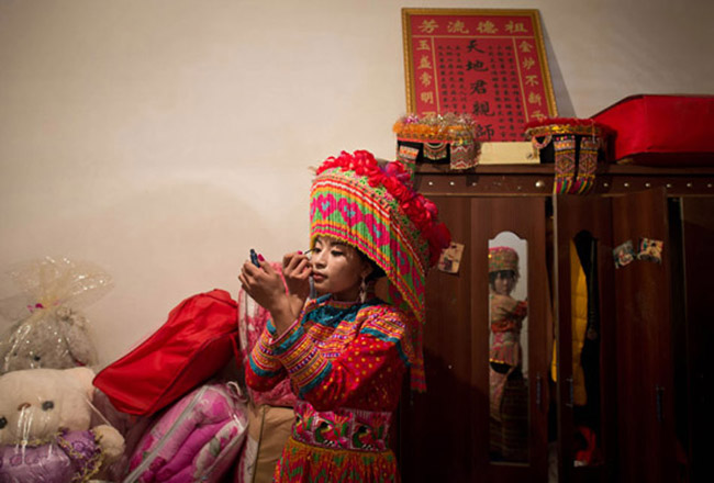 Bride Zhang Lu adorns herself before a Lisu nationality’s traditional wedding ceremony in Sichuan on Feb. 16, 2013. (Xinhua/ Jiang Hongjing)