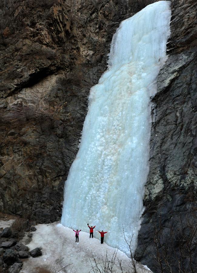 Tourists visit a frozen waterfall in the Anjiazhuang Valley of Mentougou District, a suburb of Beijing, capital of China, Feb. 23, 2013. (Xinhua/Li Wenming)