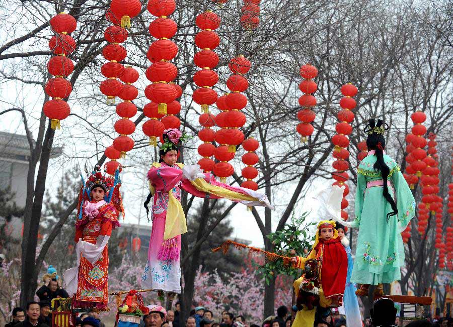 Children wearing traditional costumes perform on sticks carried by adults on the back at a temple fair to celebrate the Lantern Festival in Taiyuan Zoo in Taiyuan, capital of north China's Shanxi Province, Feb. 24, 2013. Chinese people received the Lantern Festival on Feb. 24, the 15th day of the first lunar month this year. (Xinhua/Yan Yan)