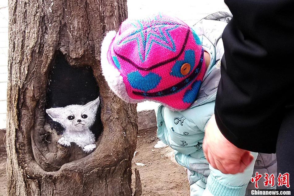 Student painter Wang Yue shows her talent by painting tree holes in Shijiazhuang, capital city of Hebei Province. (Photo/CNS)