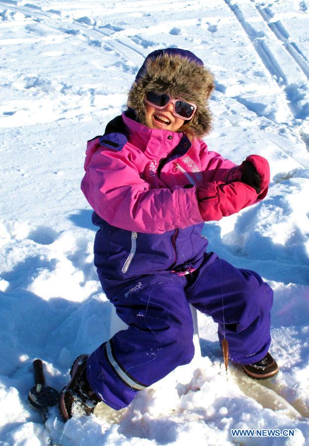 A child takes part in an ice fishing contest in Mustikkamaa, Helsinki, Finland, on Feb. 25, 2013. Winter sports are popular among children here in Finland during its long winter. (Xinhua/Zhang Xuan) 