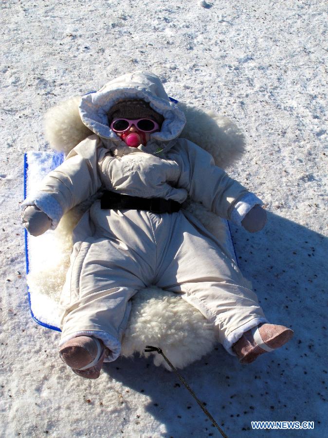 A child takes a nap on a plastic sleigh in Mustikkamaa, Helsinki, Finland, on Feb. 25, 2013. Winter sports are popular among children here in Finland during its long winter. (Xinhua/Zhang Xuan) 