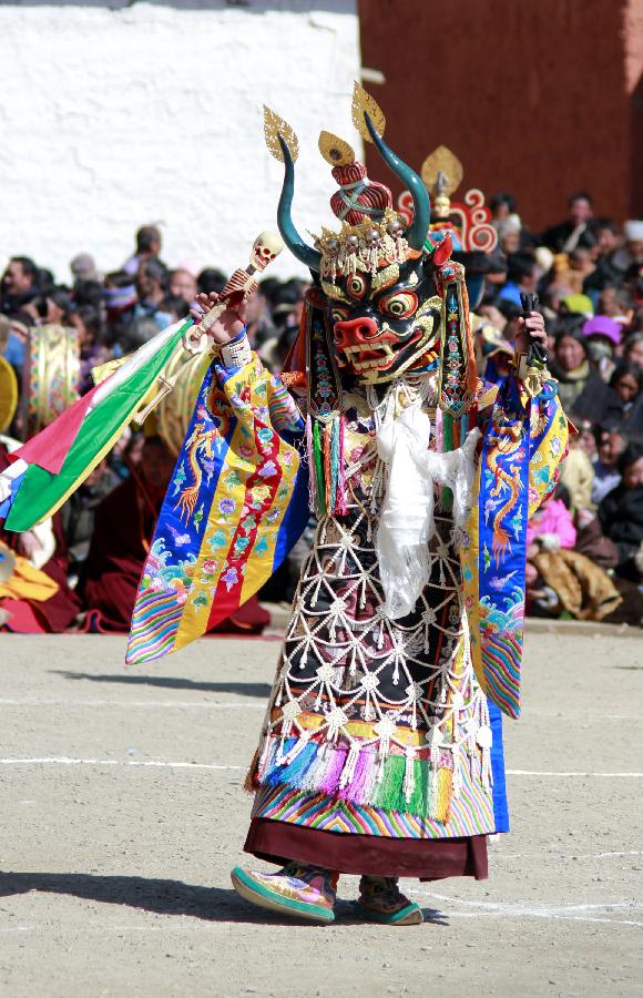 A masked Buddhist monk performs a ritual dance to pray for good fortune and harvest at the Labrang Monastery in Xiahe County, Gannan Tibetan Autonomous Prefecture, northwest China's Gansu Province, Feb. 23, 2013. The Labrang Monastery is among the six great monasteries of the Geluk school of Tibetan Buddhism. (Xinhua/Shi Youdong)