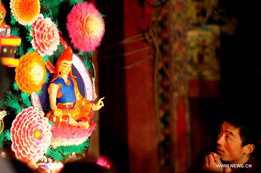 A Buddhist monk views a yak butter sculpture displayed at the Labrang Monastery in Xiahe County of Gannan Tibetan Autonomous Prefecture, northwest China's Gansu Province, Feb. 24, 2013. An annual yak butter sculpture show was held here on Sunday, the Chinese Lantern Festival, as a means to pray for good fortune and harvest. The Labrang Monastery is among the six great monasteries of the Geluk school of Tibetan Buddhism. (Xinhua/Zhang Meng) 