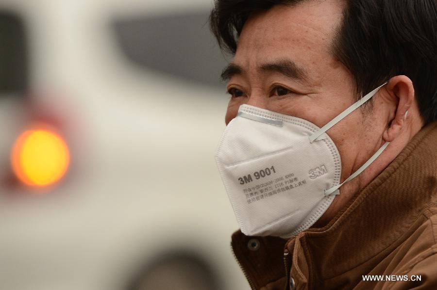 A man wears masks in fog-shrouded Jinan, capital of east China's Shandong Province, Feb. 25, 2013. Provincial meteorological authorities issued an orange fog alert on Monday morning. (Xinhua/Guo Xulei) 