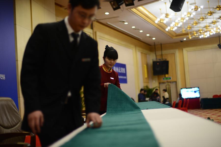 Two staff members do preparatory work in a press room of the press center for the 2013 sessions of the National People's Congress (NPC) and the Chinese People's Political Consultative Conference (CPPCC) in Beijing, capital of China, Feb. 26, 2013. The upcoming annual sessions of the NPC, China's top legislature, and the CPPCC, the country's top political advisory body, launched a press center Tuesday in the Media Center Hotel in downtown Beijing. (Xinhua/Jin Liangkuai) 