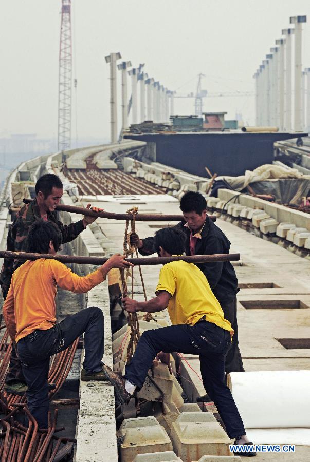 File photo taken on Oct. 20, 2011 shows construction workers working in the completing Shaoxing railway station of the Hangzhou-Ningbo high-speed railway in Shaoxing, east China's Zhejiang Province. Designed at a top speed of 350km/h, the 150-kilometer Hangzhou-Ningbo high-speed railway linking Hangzhou and Ningbo, two hub cities in Zhejiang, will reduce the travel time to 36 minitues when it is put into operation in July 2013, as expected. (Xinhua/Tan Jin) 