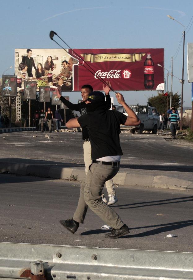 Palestinian protesters throw stones at Israeli soldiers during clashes at Hawara checkpoint near the West Bank city of Nablus on Feb. 24, 2013. (Xinhua/Nidal Eshtayeh) 