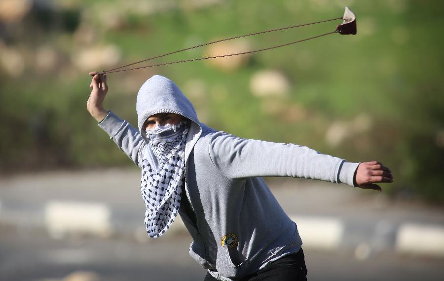 Palestinian protesters throw stones at Israeli soldiers during clashes at Hawara checkpoint near the West Bank city of Nablus on Feb. 24, 2013. (Xinhua/Nidal Eshtayeh) 