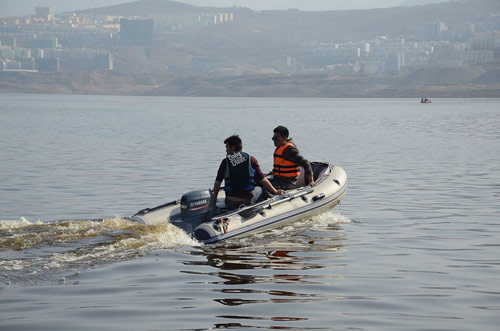 Yi Xijun, right, the son of 70-year-old hang glider enthusiast Yi Ruilong, searches for his father in Hanyuan Lake of southwest China's Sichuan Province, February 26, 2013. Yi Ruilong fell to his death in the lake on February 24. (Photo/Xinhua) 