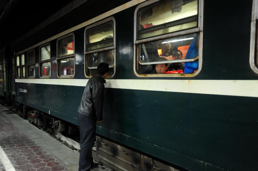 A man bids farewell to his relatives who take the train for work elsewhere at Longxi Railway Station in Longxi County, northwest China's Gansu Province, Feb. 26, 2013. Many migrant workers started their journey to work away home after the Chinese Spring Festival holidays. (Xinhua/Nie Jianjiang) 