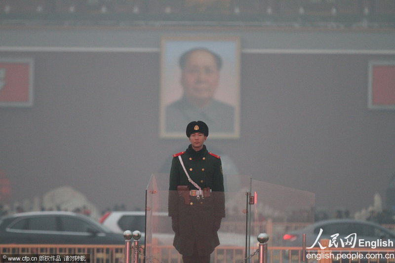 A soldier is seen in the haze that envelops the Tiananmen Square and cuts the visibility, Feb. 28, 2013. Sand and haze hit Beijing in a row from Wednesday, causing serious air pollution and poor visibility. The Meteorological Bureau of Beijing issued blue alert for strong gale and yellow alert for haze yesterday. (Photo/CFP)