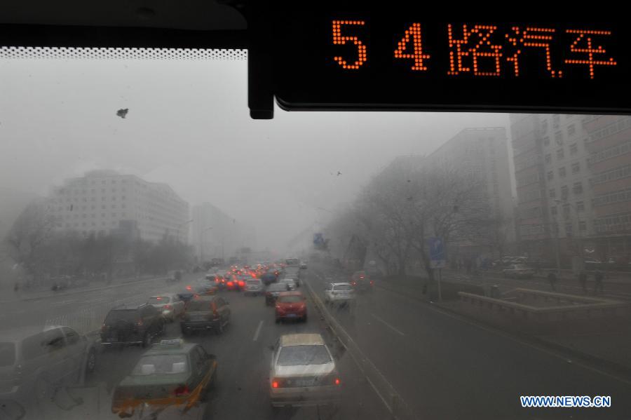 A bus runs on a fog-shrouded road in Beijing, capital of China, Feb. 28, 2013. Beijing was hit by heavy fog on Thursday morning. The fog led to reduced visibility and degenerated air quality. The city also issued high wind and haze alerts on the same day. (Xinhua/Lu Peng)