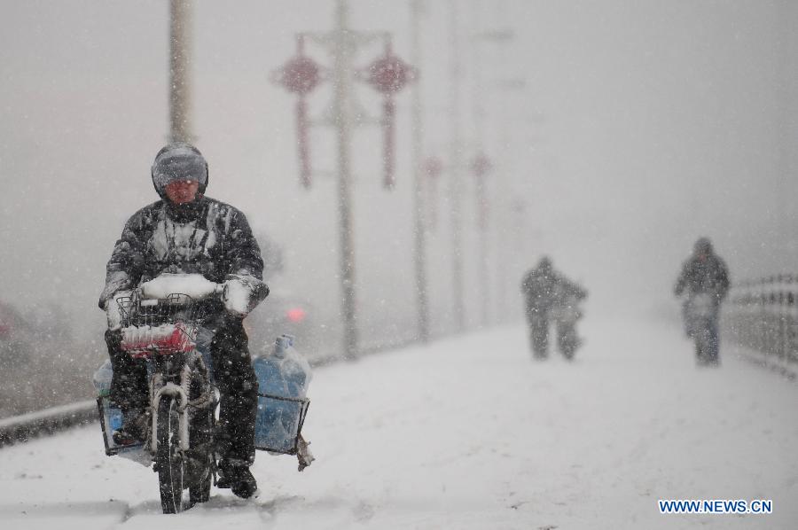 A man rides scooter in snow in Shenyang, capital of northeast China's Liaoning Province, Feb. 28, 2013. Liaoning was hit by a snowstorm on Thursday. (Xinhua/Pan Yulong) 
