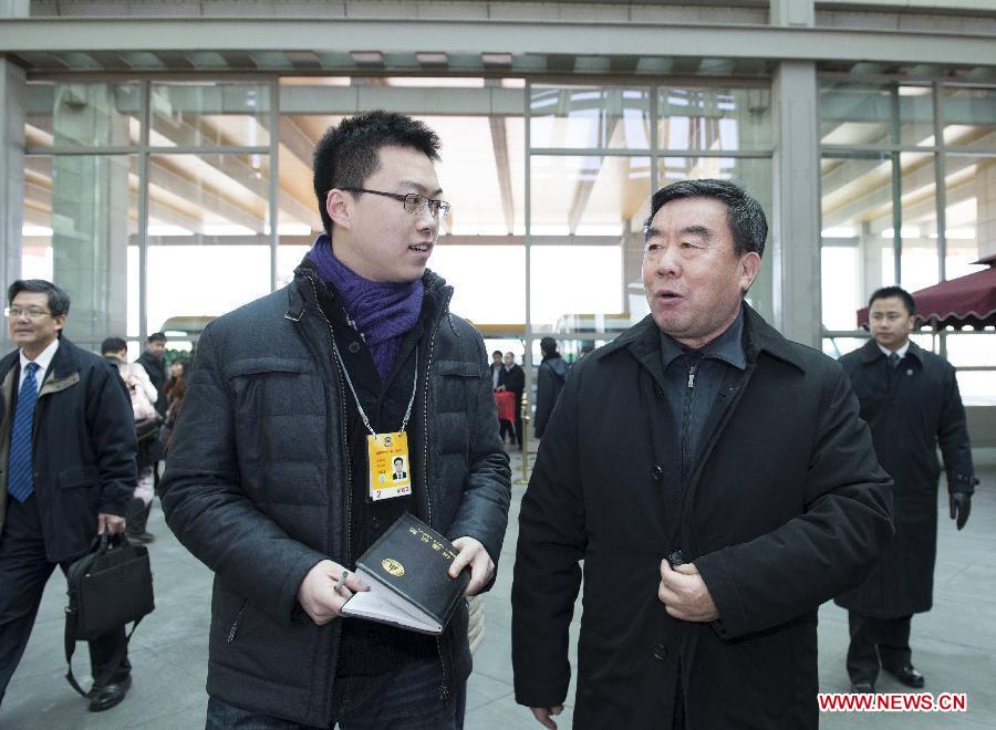 Fu Kecheng (R front), a member of the 12th National Committee of the Chinese People's Political Consultative Conference (CPPCC) from east China's Jiangxi Province, receives an interview upon his arrival in Beijing, capital of China, March 1, 2013. The first session of the 12th CPPCC National Committee will open on March 3. (Xinhua/Wang Ye)